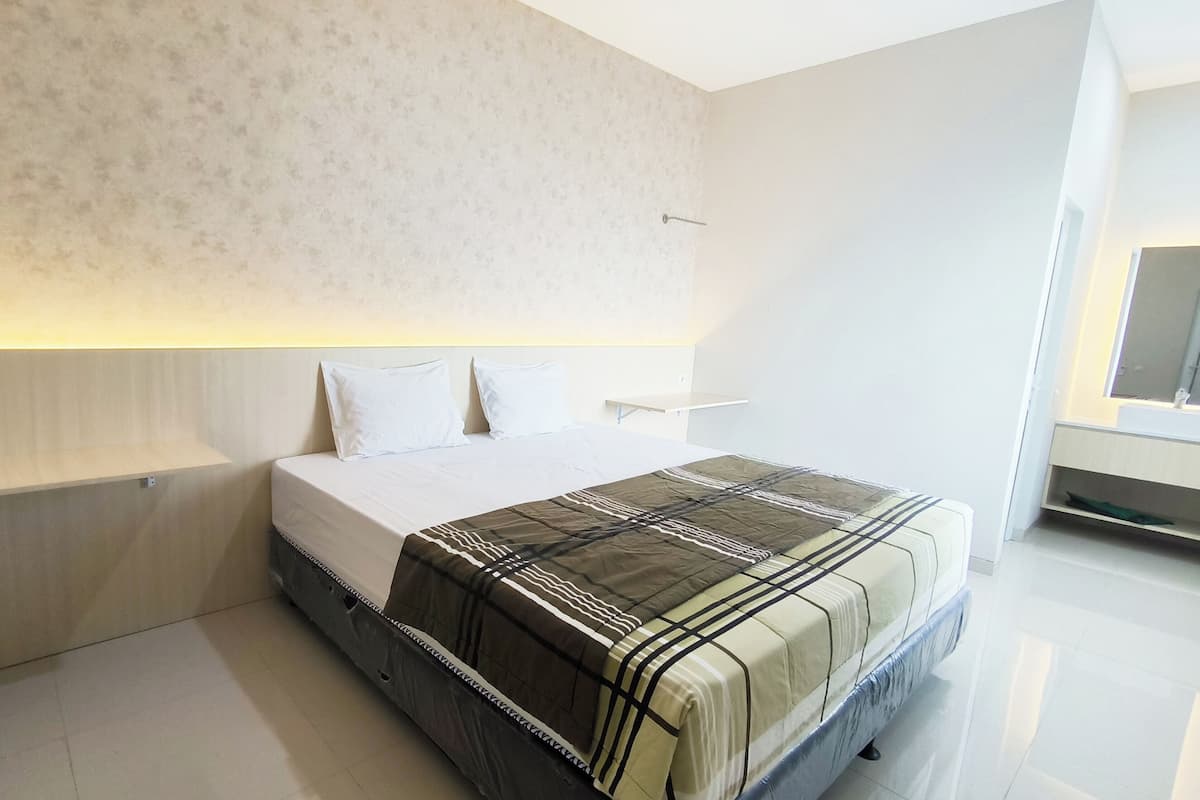 A modern bedroom with a bed, bedside tables, and a headboard.