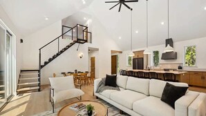 A spacious living area with a staircase, a dining area, and a kitchen. - Modern Luxury Retreat · Game Loft · Near Bay (Egg Harbor)