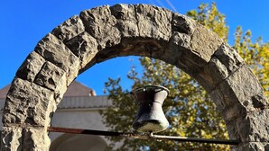 A stone fountain with a metal spout, set within an arched stone structure, surrounded by a paved area and a building in the background. - Infinity Experience Lovely house with sea view terrace (Scala)