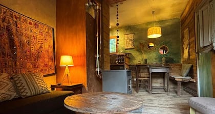 Like a cabin, between forest and river, with a terrace facing the garden.