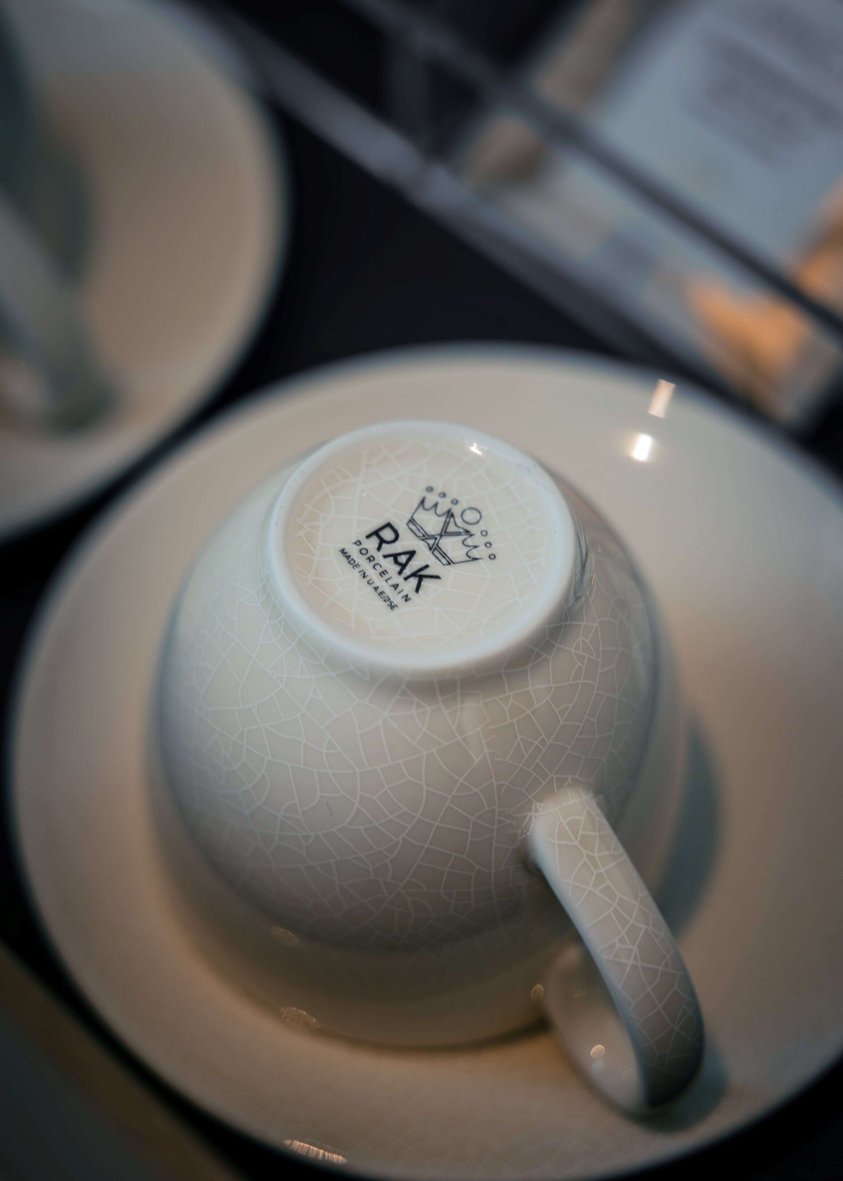 A white ceramic cup with a textured pattern and the text "RAK PORCELAIN MADE IN JAPAN" on the bottom.