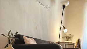 A living room with a dark sofa, a round wooden table, and a lamp. - La Voltina – The ideal starting point for exploring Lucca and the Garfagnana (Diecimo)