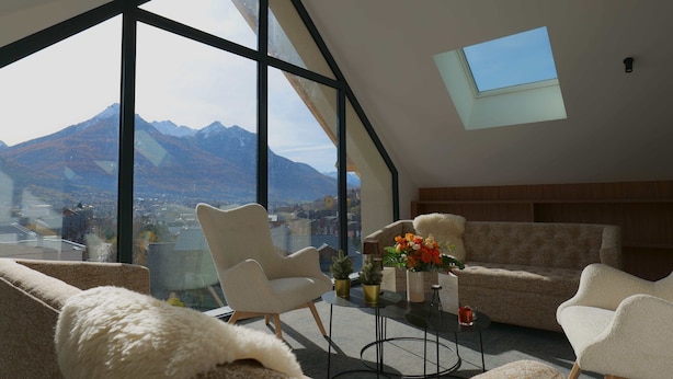 A modern living room with large windows, a sofa, a coffee table, and a view of mountains. - Garrigae Caserne de Briançon & Spa - les Cinq Mondes (Briançon)