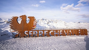 A large metal sign with the text "Sierre Chevalier" and a stylized eagle design, set against a snowy mountain backdrop. - Garrigae Caserne de Briançon & Spa - les Cinq Mondes (Briançon)