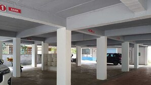 Un parking avec des piliers blancs, une enseigne plate et une enseigne de banque.