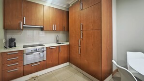 A kitchen with wooden cabinets, a stainless steel oven, and a white countertop. - Desconectaengalicia Castiñeiros (Sanxenxo)