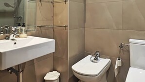 A modern bathroom with a white sink, a toilet, and a glass shower enclosure. - Desconectaengalicia Castiñeiros (Sanxenxo)