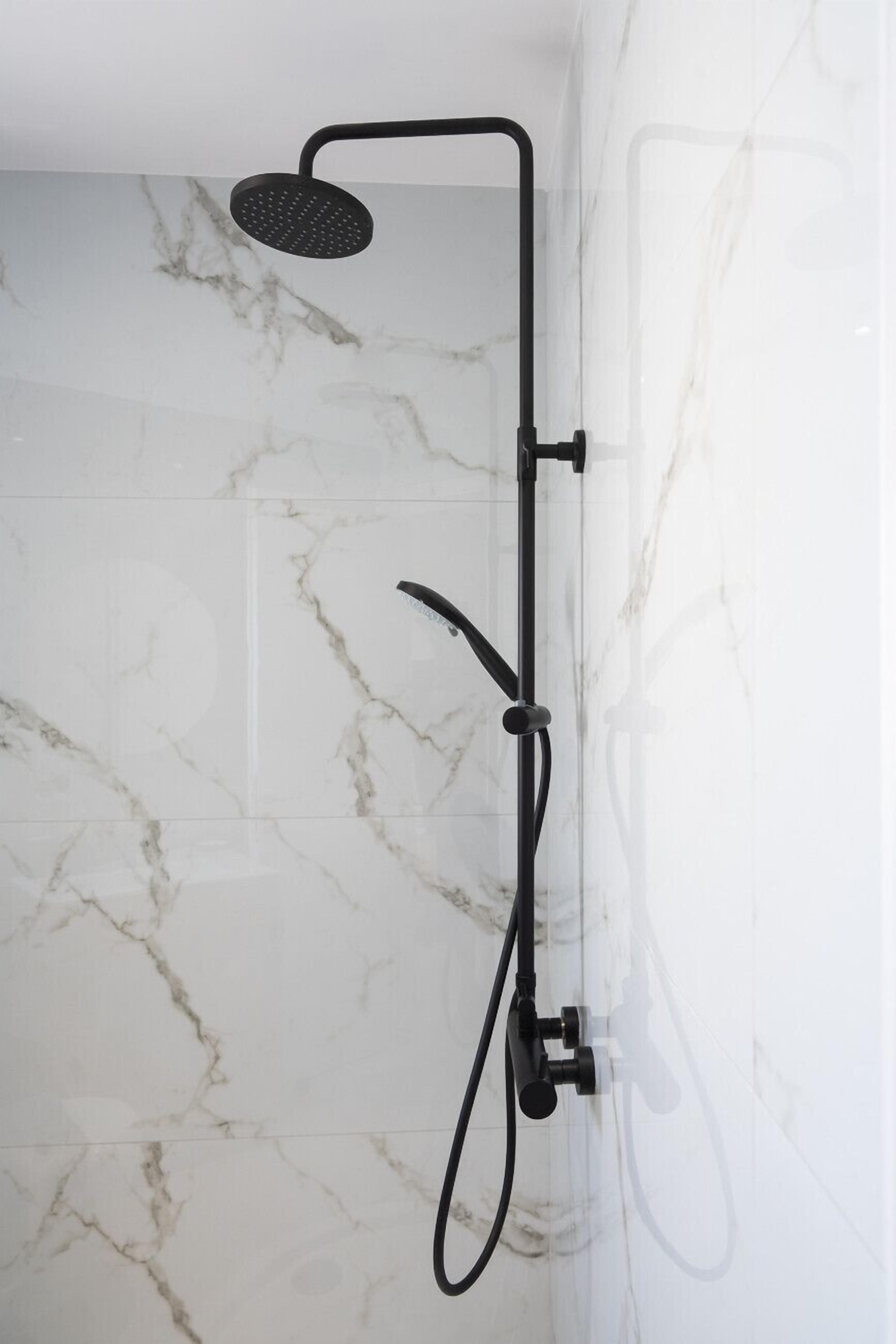 A modern shower with a handheld showerhead and a handheld hose.