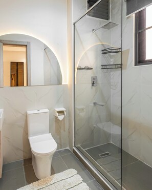 A modern bathroom with a glass-enclosed shower, a toilet, and a sink. - George Residence Lekki Phase 1 (Lekki)