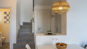 A staircase leading to a door, a table with a fruit bowl, and a hanging light fixture. - Villa Etoni, stunning sea views, infinity pool and privacy (Kalamitsi)