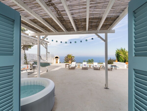 A rooftop terrace with a hot tub, lounge chairs, and a pergola with string lights. - Villa Etoni, stunning sea views, infinity pool and privacy (Kalamitsi)