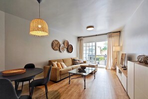A modern living room with a sofa, coffee table, and dining area.