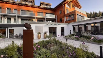Un bâtiment moderne doté d’une cour intérieure aménagée avec des espaces de détente et des plantes en pot.