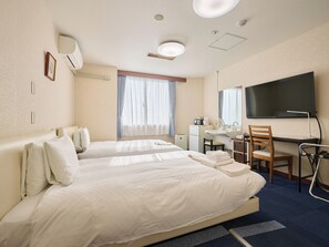 A hotel room with two beds, a desk with a chair, a TV, and a window with curtains. - Okasan Hotel (Ogaki)