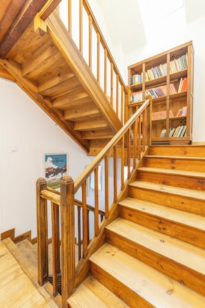 A wooden staircase with a handrail leading to a landing.