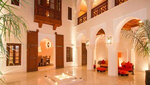 A spacious lobby with high ceilings, arched doorways, and a central fountain.