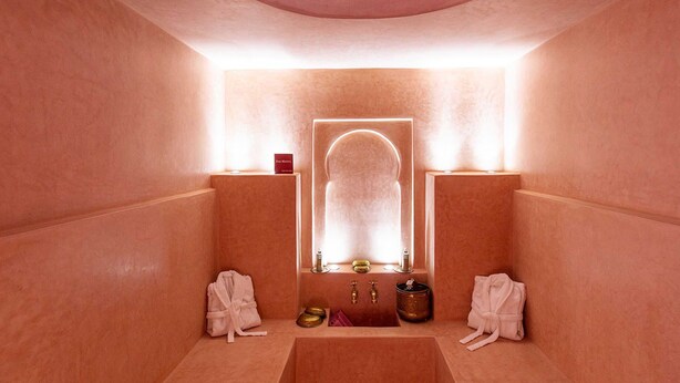 Casa de spa com um espelho grande, duas pias e toalhas.