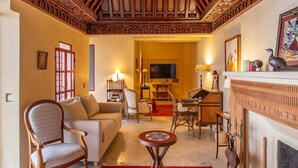 Uma sala de estar acolhedora com sofá, poltronas, mesa de centro e lareira.