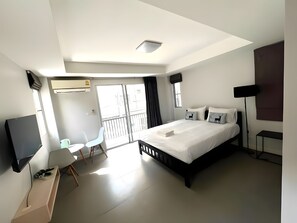 A modern hotel room with a large bed, a desk with a computer, a chair, and a TV. - Mitr Inn Mrt Samyot Station - The Grand  (Bangkok)