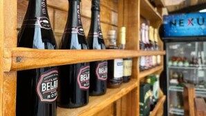 A row of bottles labeled 'BELLA ROSE' on a wooden shelf in a store. - Network Hotel and Suites (Ilesa)
