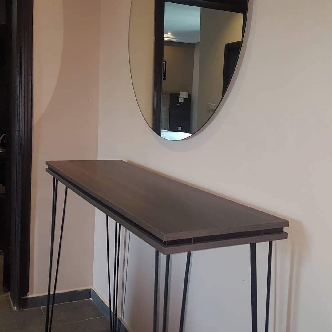Un coin avec une table en bois foncé et un miroir au mur.