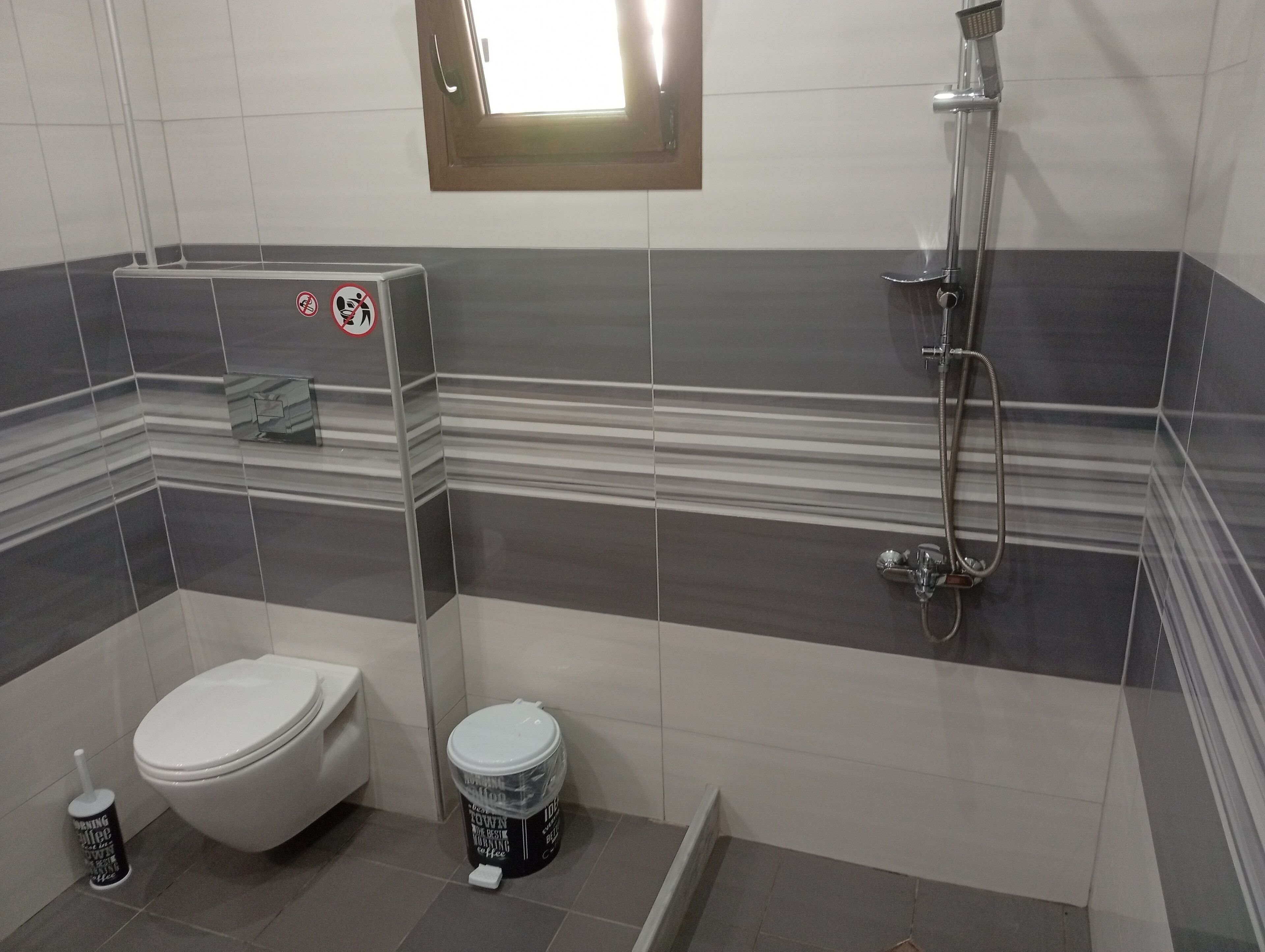 Een badkamer met toilet, bidet en douche.