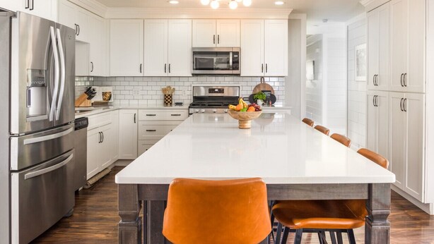 A modern kitchen with white cabinetry, stainless steel appliances, and a central island with seating. - Savannah Retreat|Htd Pool|Pickleball|Hot tb|Golf (Savannah)