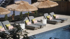 A poolside area with lounge chairs and thatched umbrellas, a tiled deck, and a pool. - Savannah Retreat|Htd Pool|Pickleball|Hot tb|Golf (Savannah)