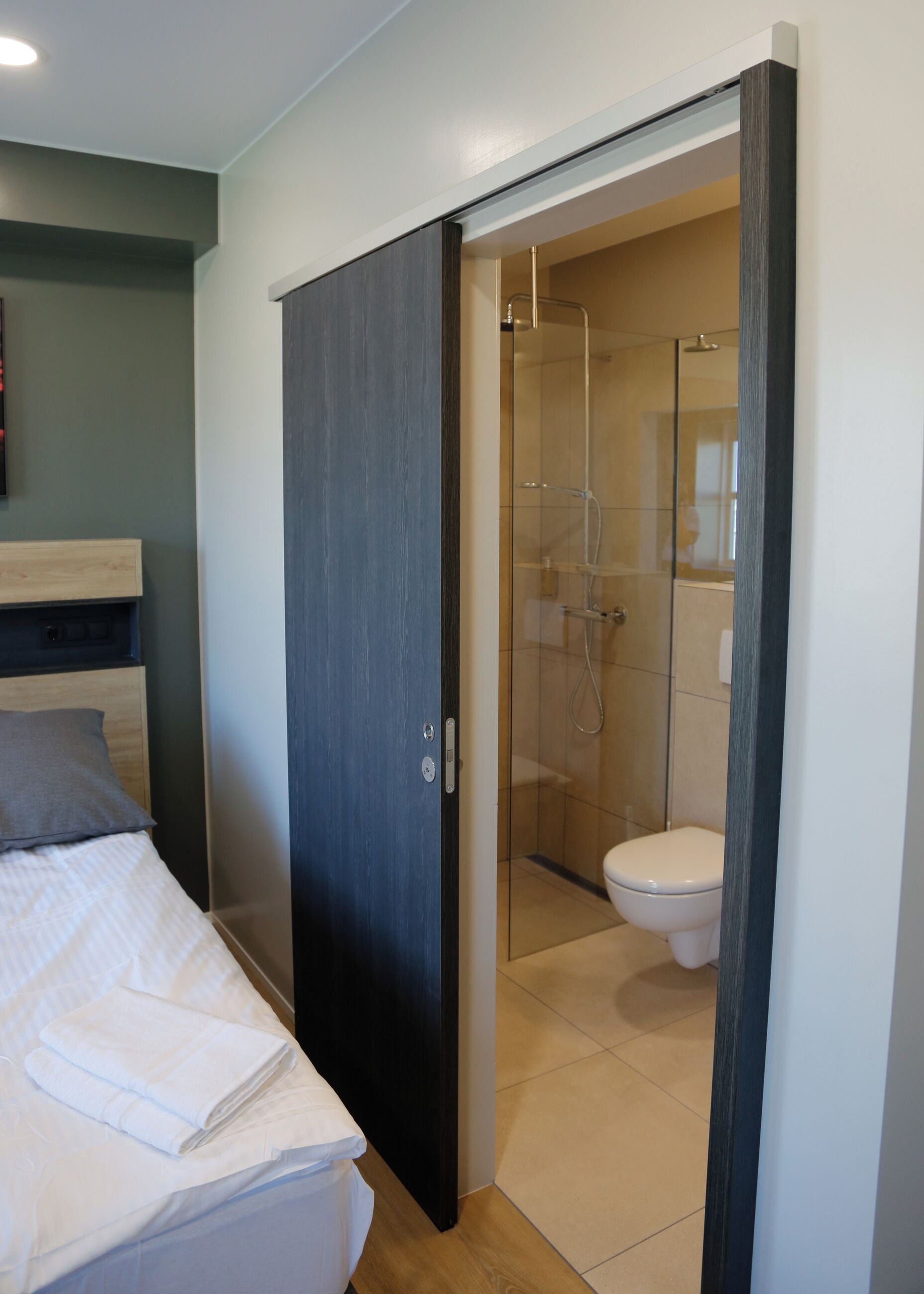 Quarto com cama, mesa de cabeceira e guarda-roupa.