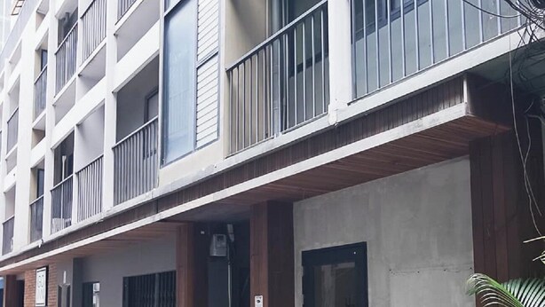 Ein mehrstöckiges Gebäude mit Balkonen, großen Fenstern und einem gut sichtbaren Eingang.