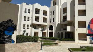 A multi-story building with balconies and a courtyard.