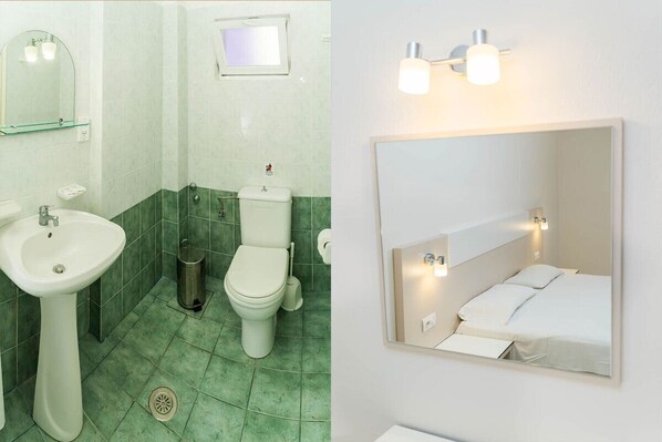 A bathroom with a sink, toilet, and mirror.