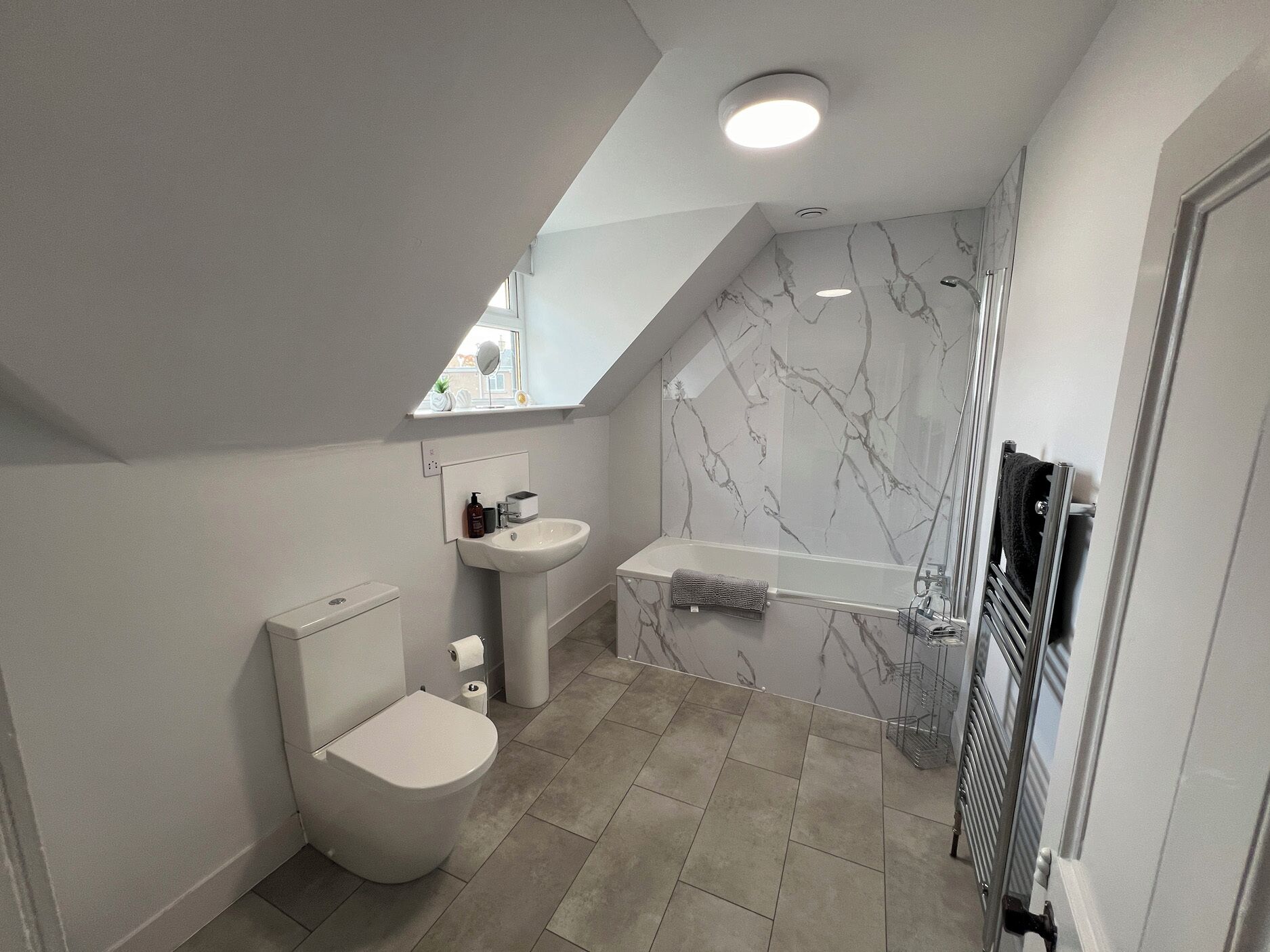 Un baño moderno con inodoro, lavabo y bañera.