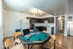 Une pièce équipée d’une table de billard, de chaises, d’un four à micro-ondes et de placards.