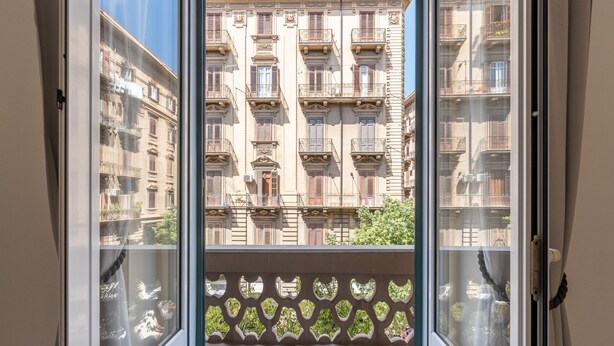 A balcony with a view of a building with multiple balconies and windows. - Casa Markea by Wonderful Italy (Palermo)