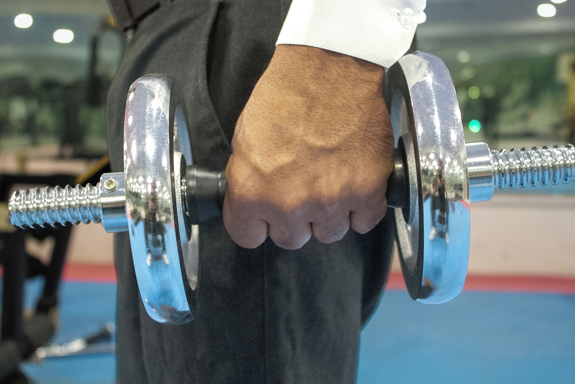 Primo piano di una mano che stringe un bilanciere da palestra.