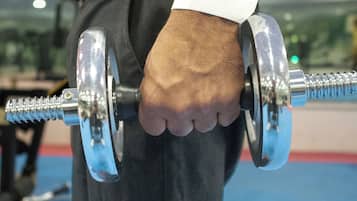 Primo piano di una mano che stringe un bilanciere da palestra.