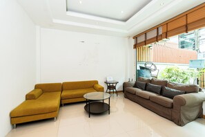 A modern living room with two sofas, a coffee table, and a small side table. - Yon INN Sukhumvit 4 - BTS Nana (Bangkok)
