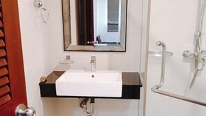 A bathroom with a white sink, a mirror, and a glass shower enclosure. - Yon INN Sukhumvit 4 - BTS Nana (Bangkok)