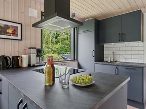 Een koelkast, een vaatwasser, kookgerei, borden en bestek