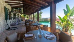 A covered outdoor seating area with wicker furniture, a pool view, and a sign indicating 'Lounge 3'. - Corfelia Seaview Suites (Corfu)