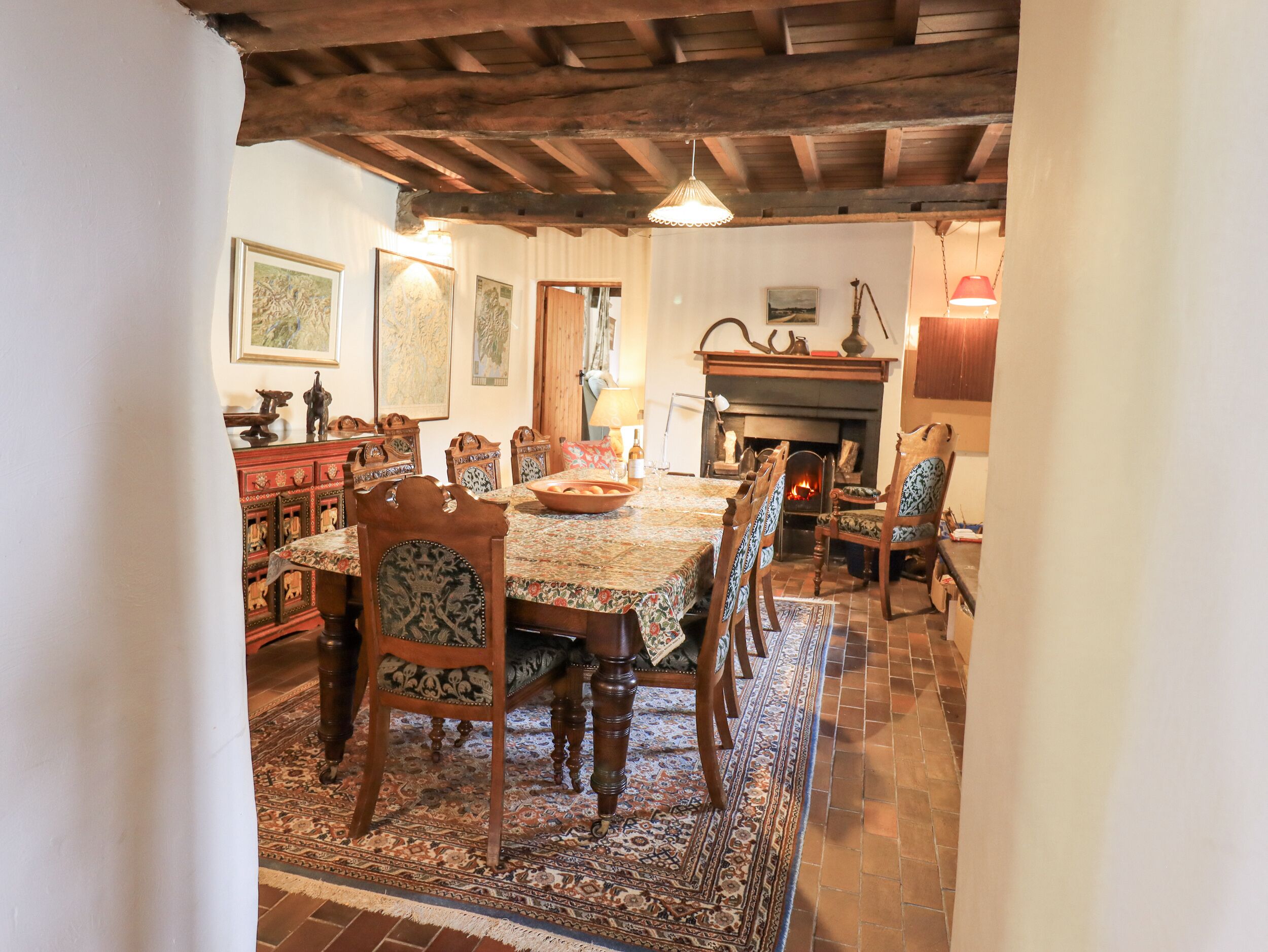 Un comedor tradicional con una mesa de madera, sillas y una chimenea.