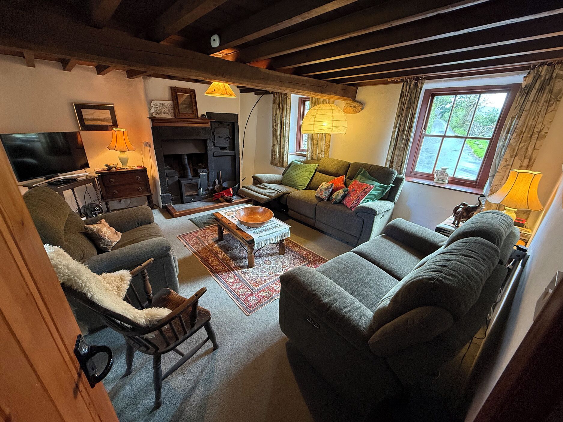A cozy living room with a fireplace, comfortable seating, and a television.