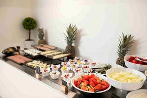 A buffet with various food items including meats, cheeses, fruits, and vegetables. - ELEA SUN HOTEL (Kamari)