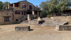 A stone building with a sloped roof, a small staircase leading to a door, and a gravel ground.