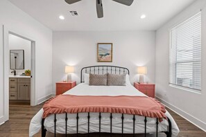 A bedroom with a bed, bedside tables, a nightstand, a window with blinds, a ceiling fan, and a painting on the wall. - NEW•Voodoo House•KING Bed• (Lafayette)
