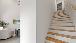 A modern staircase with wooden steps and a handrail, leading to an upper floor. - NEW•Voodoo House•KING Bed• (Lafayette)