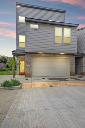 A modern two-story house with a garage, a small front yard, and a brick exterior. - NEW•Voodoo House•KING Bed• (Lafayette)
