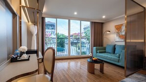 A spacious living room with a large window, a sofa, a chair, a coffee table, and a decorative vase. - Splendid Secret Hotel (Hanoi)