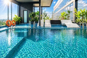 A rooftop infinity pool with clear blue water, surrounded by potted plants and a modern building with large windows. - Splendid Secret Hotel (Hanoi)